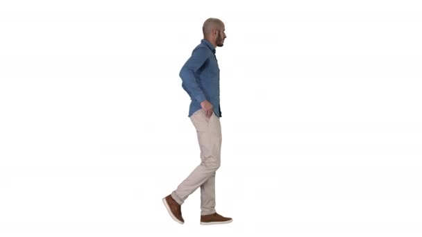 Fiducioso nel suo modello di stile walkin con le mani in tasca su sfondo bianco. — Video Stock