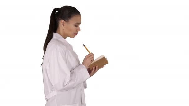 Successful medical doctors making notes while walking on white background. — Stock Video