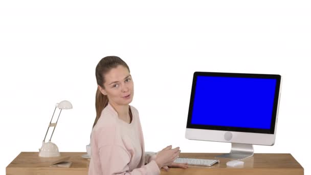 Encantadora mujer que presenta algo en la pantalla de la computadora hablando con la cámara Pantalla azul Mock-up Display sobre fondo blanco. — Vídeos de Stock