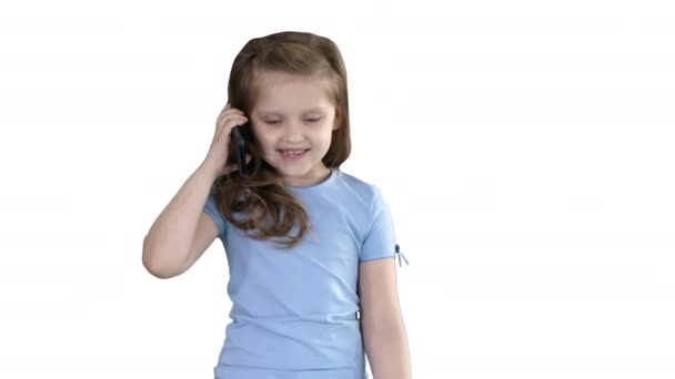Pequena menina bonito fazendo um telefonema enquanto caminhava sobre fundo branco . — Vídeo de Stock