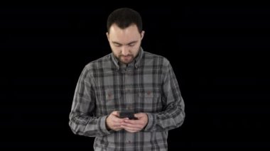 Genç adam yürüyor ve akıllı telefon kullanıyor, Alfa Kanalı.