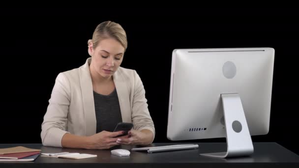 Kvinna med mobiltelefon vid skrivbordet, Alpha Channel — Stockvideo