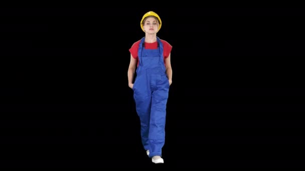 La joven ingeniera con casco de seguridad amarillo caminando, Alpha Channel — Vídeos de Stock