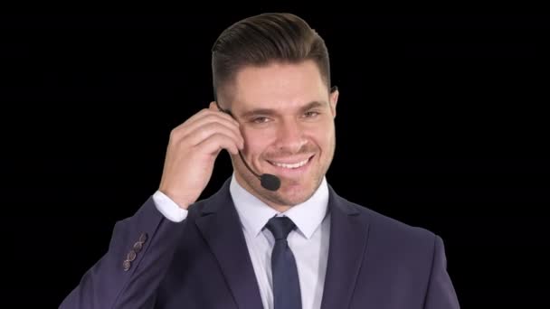 Jóképű üzletember fülhallgatóval a kamerába néz és mosolyog, Alpha Channel — Stock videók