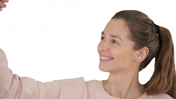 Sonriente mujer de pelo rubio alegre haciendo selfie sobre fondo blanco. — Vídeos de Stock
