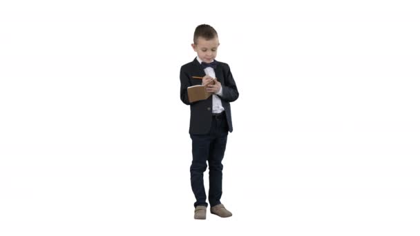 Pojke i en formell kläder skriver i Checklista eller anteckningsbok på vit bakgrund. — Stockvideo