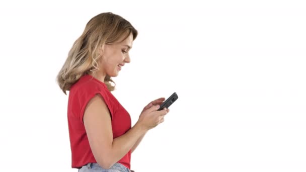 Joyeux mignon belle jeune femme jouer à des jeux par téléphone mobile sur fond blanc . — Video