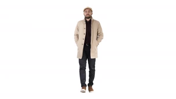 Fiducioso bel giovane uomo che indossa cappotto a piedi su sfondo bianco . — Video Stock