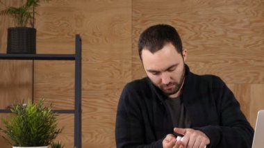 Genç işadamı işyeri dizüstü bilgisayar önünde otururken ilaç alır.