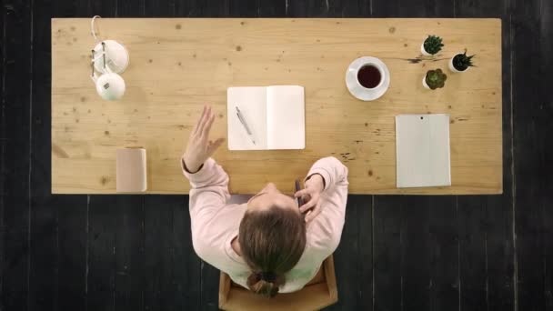 Attraktive, glückliche junge Geschäftsfrau, die im Büro auf einem Smartphone plaudert — Stockvideo