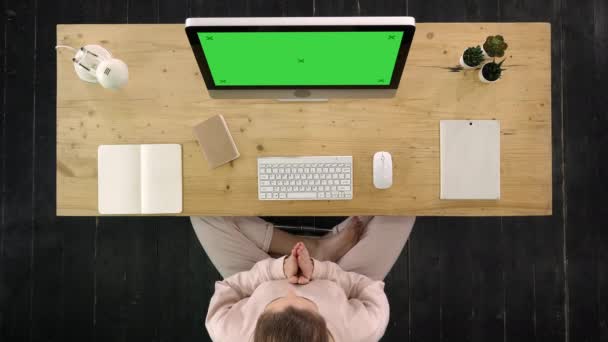 Dame dans occasionnel assis devant le bureau et ordinateur en pose de lotus. Affichage de maquette d'écran vert . — Video