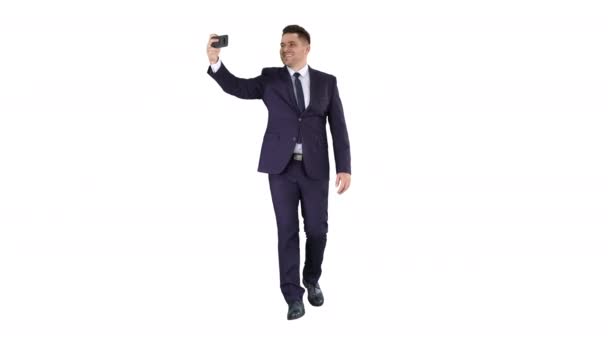 Przystojny mężczyzna w garniturze robi sobie selfie na białym tle. — Wideo stockowe