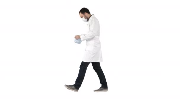 Walking doctor puting medical mask on on white background. — Stock Video