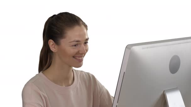 Φοιτητής ξανθιά κορίτσι κοιτάζοντας την οθόνη του υπολογιστή και χαμογελά σε λευκό φόντο. — Αρχείο Βίντεο