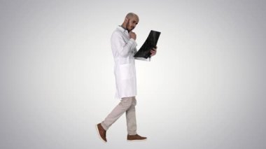 Genç erkek hekim okuma ve degrade arka plan üzerinde yürürken mri beyin taraması gözden.