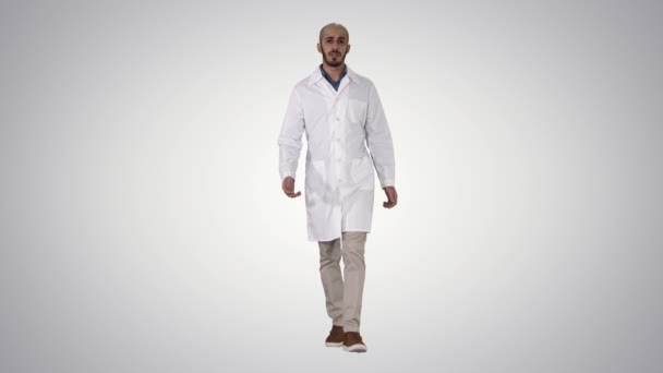Barátságos férfi orvos gyalogos és beszél látszó-ban fényképezőgép gradiens háttér. — Stock videók