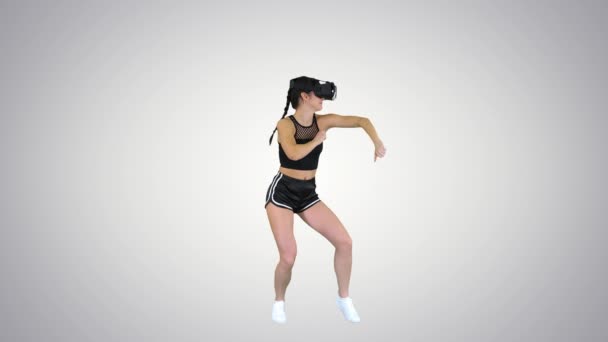 Menina jogando realidade virtual dançando jogo Dançarino experiente no fundo gradiente . — Vídeo de Stock