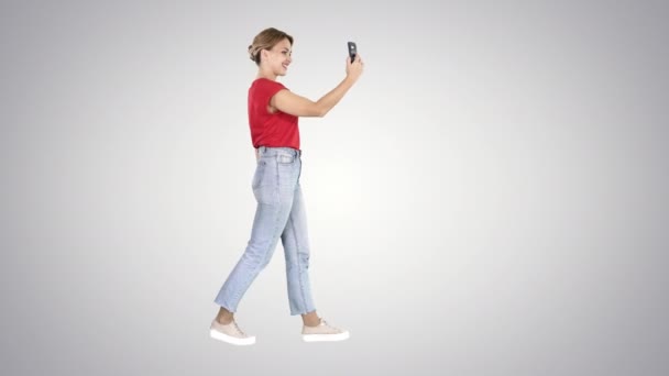 Young cute lady is having video call on her phone Video blog on gradient background. — Stock Video