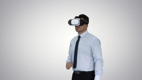 Biznesmen w okularach VR i interakcja z obiektami wirtualnej rzeczywistości na tle gradientu. — Wideo stockowe