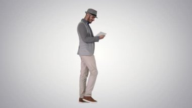 Tablet kullanan ve degrade arka planda uyanırken gülümseyen rahat adam.