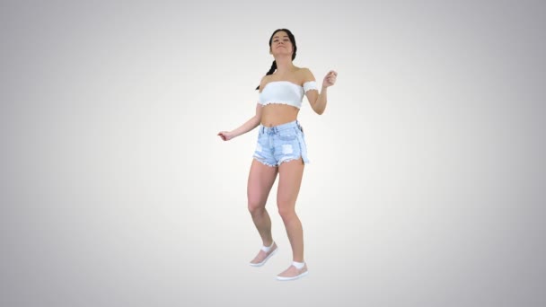 女の子が踊り、グラデーションの背景に電話で呼び出しを行う. — ストック動画