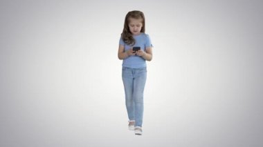 Küçük sevimli kız degrade arka plan üzerinde mobil akıllı telefon ilginç bir bilgi ile şaşırttı.