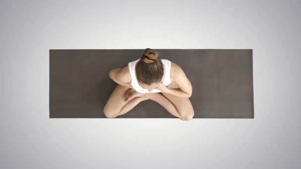 Yoga meisje ademhaling in Lotus pose met haar handen op haar buik en borst op gradiënt achtergrond. — Stockvideo