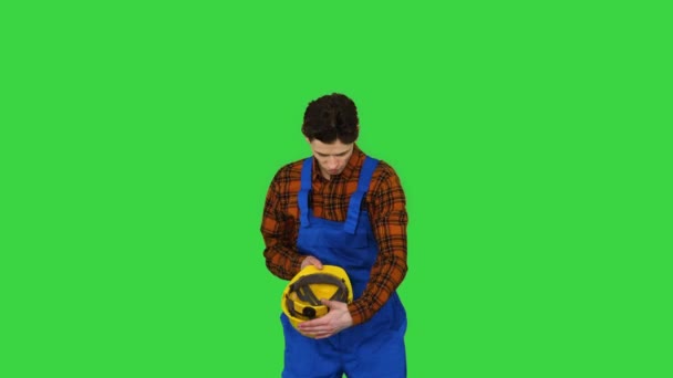 Einzelner Bauarbeiter setzt Schutzmütze auf und tanzt cool auf einem Green Screen, Chroma Key. — Stockvideo