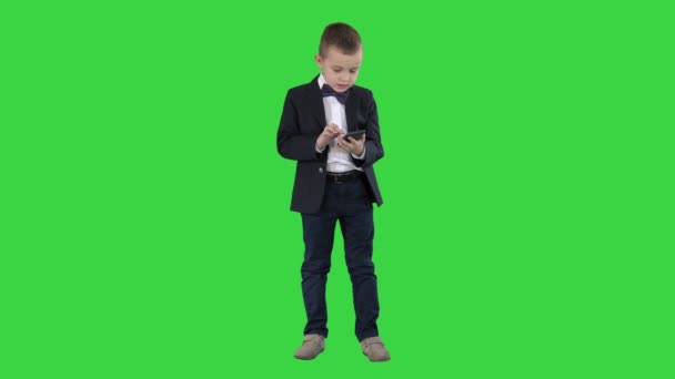 Intelligent garçon est SMS message, jouer à des jeux en ligne, envoyer des images, télécharger de la musique, des films sur un écran vert, Chroma Key . — Video