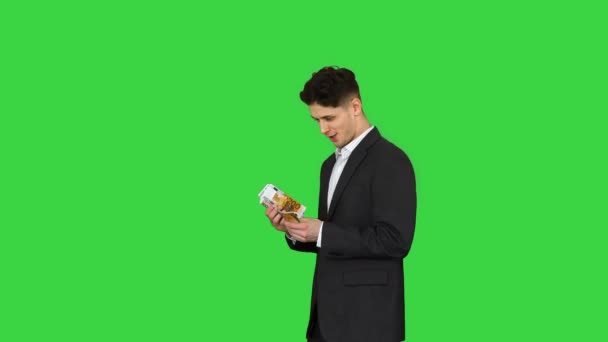 Νεαρός χαρούμενος επιχειρηματίας που χορεύει μετά την καταμέτρηση μισθού Κερδίστε χορό σε μια πράσινη οθόνη, Chroma Key. — Αρχείο Βίντεο
