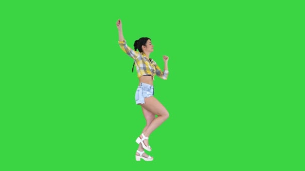 Herrliche süße Mädchen in Jeans Shorts, Turnschuhen, tanzen auf einem Green Screen, Chroma Key. — Stockvideo