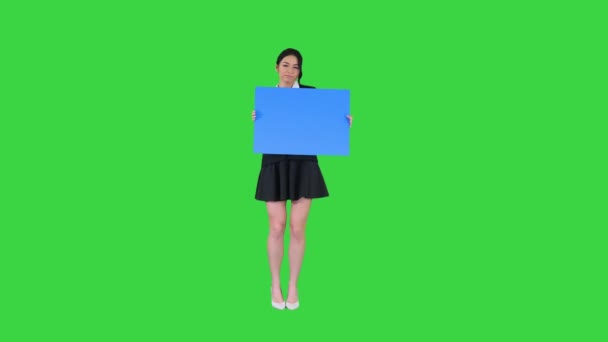 Une femme élégante dansant et tenant une affiche vide sur un écran vert, maquette bleue . — Video