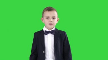 Bir takım elbise dostu küçük çocuk Merhaba diyor ve sonra yeşil ekranda bye diyor, chroma key.
