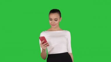 Yeşil ekranda bir cep telefonu manifatura kullanarak güzel genç kadın, Chroma anahtar.
