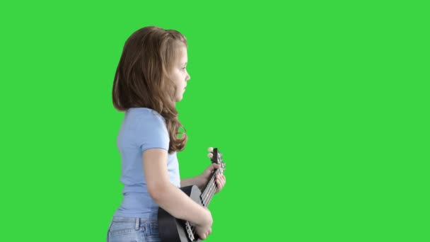 Una niña caminando con ukelele en las manos en una pantalla verde, Chroma Key . — Vídeos de Stock