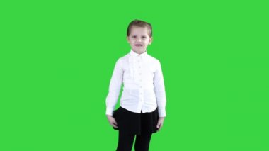 Mutlu sevimli küçük kız çerçeve içinde yürüyüş ve Yeşil Ekranda kameraya konuşan, Chroma Key.