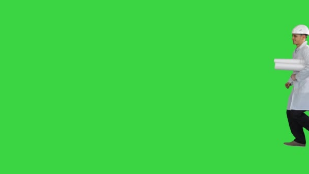 Ingeniero sosteniendo un plano de su trabajo caminando por una pantalla verde, Chroma Key. — Vídeo de stock