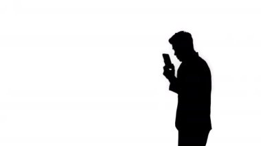 Siluet Telefonda tartışırken dans eden genç bir işadamı.