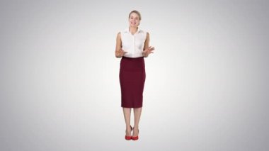 Resmi kıyafetler içinde büyüleyici gülümseyen enerjik kadın kameraya konuşuyor ve degrade arka planda yanları işaret.