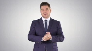 Kamera seyir ve degrade arka plan üzerinde konuşurken yakışıklı işadamı.