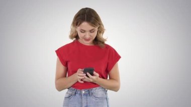 Degrade arka planda akıllı telefonunu kullanarak t shirt genç güzel kadın.