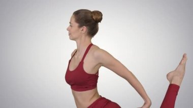 Güzel genç kadın Eka Pada Rajakapotasana Yoga Pozu, Tek bacaklı Kral Güvercin Duruşu gradyan arka planda.