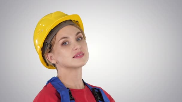 Female construction worker greeting on gradient background. — Stock Video