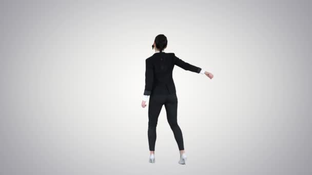 Чарівна впевнена молода бізнес-леді танцює на градієнтному фоні . — стокове відео