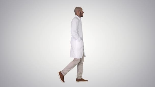 Doctor lopen met de handen in zakken op gradiënt achtergrond. — Stockvideo