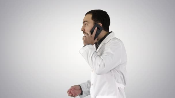 Doctor talking on mobile phone on gradient background. — Stock Video
