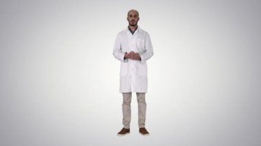 Tıbbi ceket Arap doktor adam konuşma ve degrade arka plan üzerinde el ile bir şey sunan.