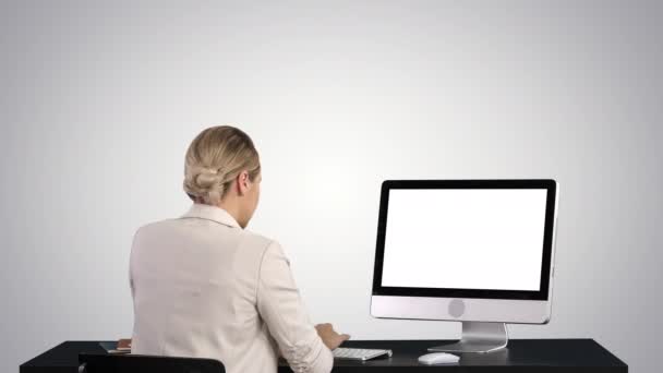 Жінка працює на моніторі на градієнтному фоні . — стокове відео