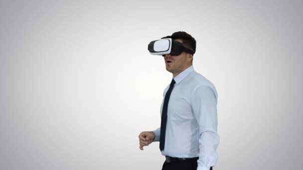 Astonished young businessman wearing VR glasses Concept of the future technology on gradient background. — Stock Video