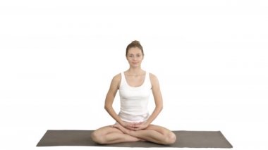 Genç güzel sarışın kadın yoga yapıyor ve beyaz arka planda gülümsüyor..